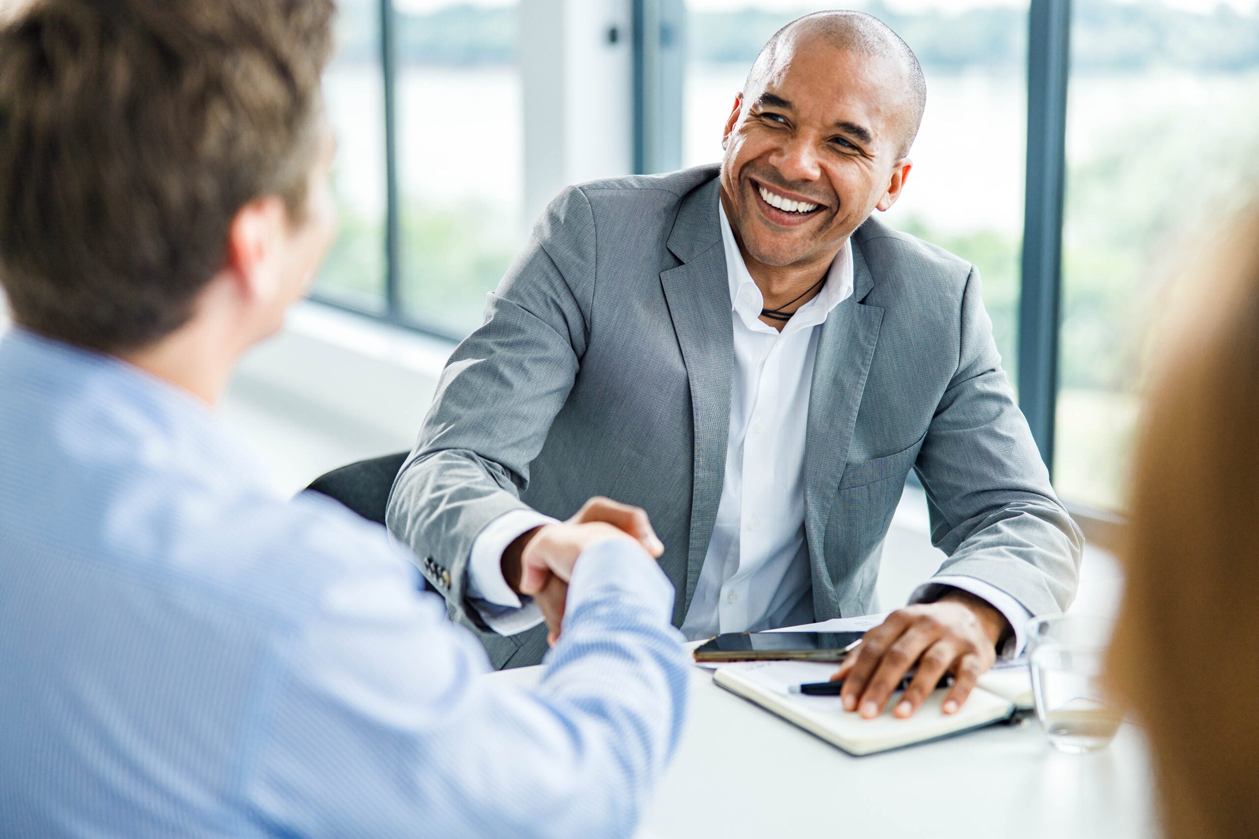 Two businessmen shaking hands over a reverse mortgage illustration