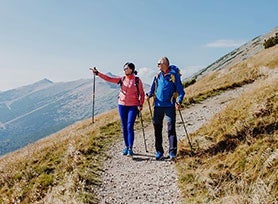 Retired couple enjoying their hiking vacation with funds received from their Finance of America HomeSafe Second reverse mortgage loan