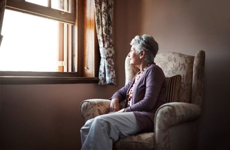 A woman on her couch wondering if she can outlive a reverse mortgage