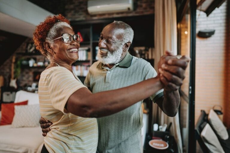 A couple dancing in their home because they understand their options to receive reverse mortgage proceeds